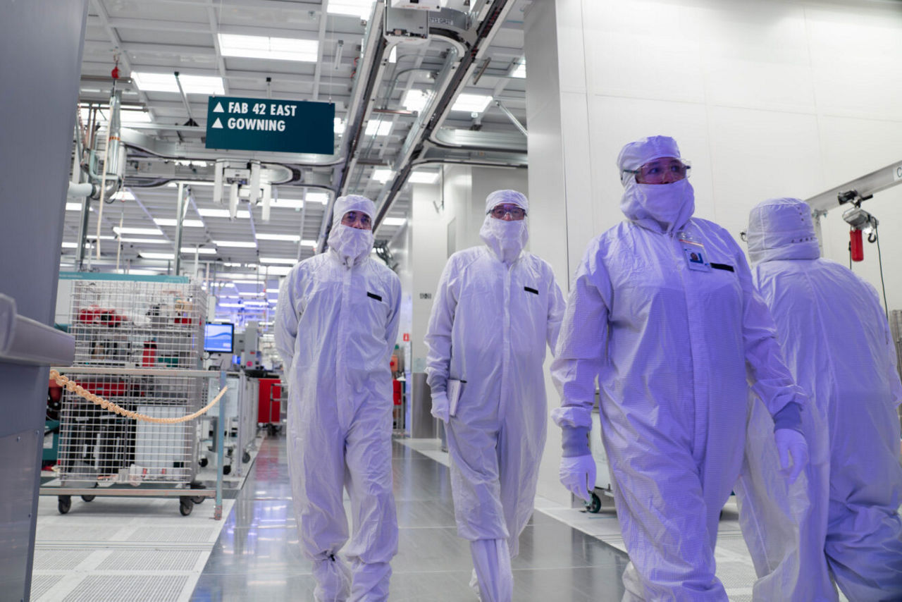 Os líderes de manufatura da Intel, juntamente com o CEO Lip-Bu Tan (centro), estão vestidos com trajes de coelho de sala limpa enquanto visitam a Fab 52 no campus da Intel Ocotillo em Chandler, Arizona, em outubro de 2025. A Fab 52 é a casa dos EUA para o Intel 18A, onde o Panther Lake, a próxima geração de processadores para laptops clientes e consumidores da Intel, está sendo fabricado. (Crédito: Intel Corporation)