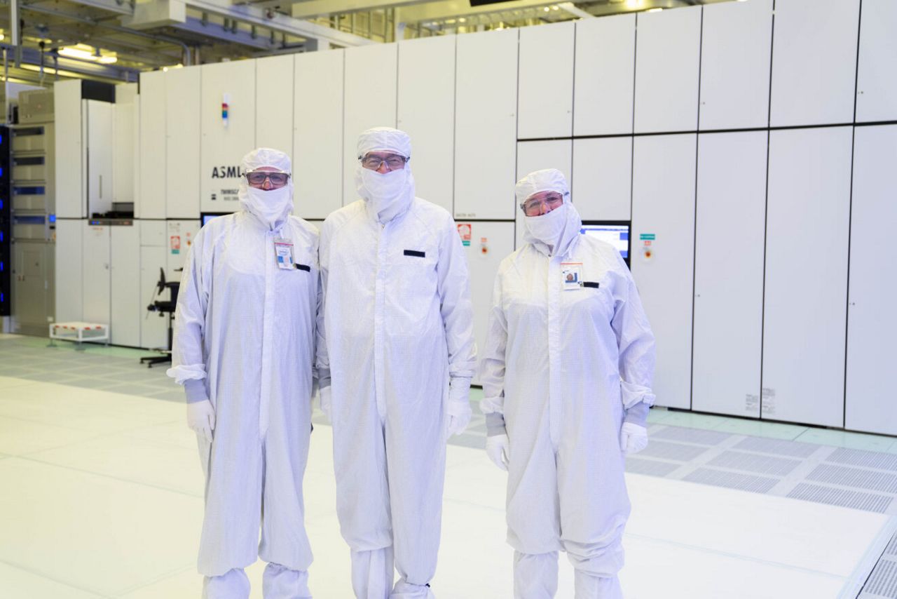 Intel CEO Lip-Bu Tan (center) stands with Jason Reid, Intel 18A Lithography Dept. Manager, (left) and Zivit Katz-Tsameret (right), Vice President, Intel Foundry Manufacturing and Supply Chain and Arizona Factory Manager, in front of an EUV lithography scanner used to print the next generation of Intel Core Ultra processors, code-named Panther Lake. Panther Lake is the first product to be manufactured on Intel 18A at Fab 52. Tan toured the Chandler, Arizona facility in October 2025.