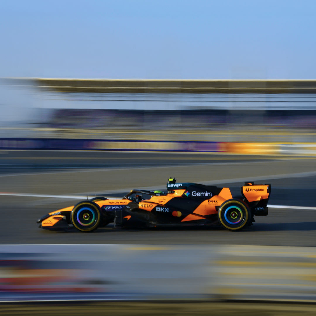 Image of a yellow McLaren racing car in motion on a speedway