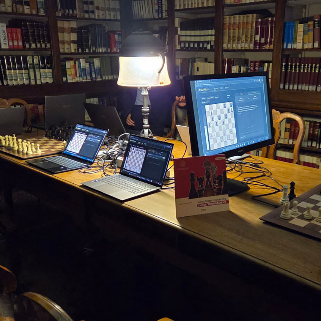 The AI Analysis Room in the University of Bologna library is set up with laptops, monitors, and chessboards.