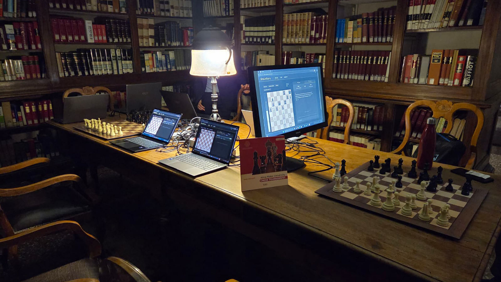 The AI Analysis Room in the University of Bologna library is set up with laptops, monitors, and chessboards.