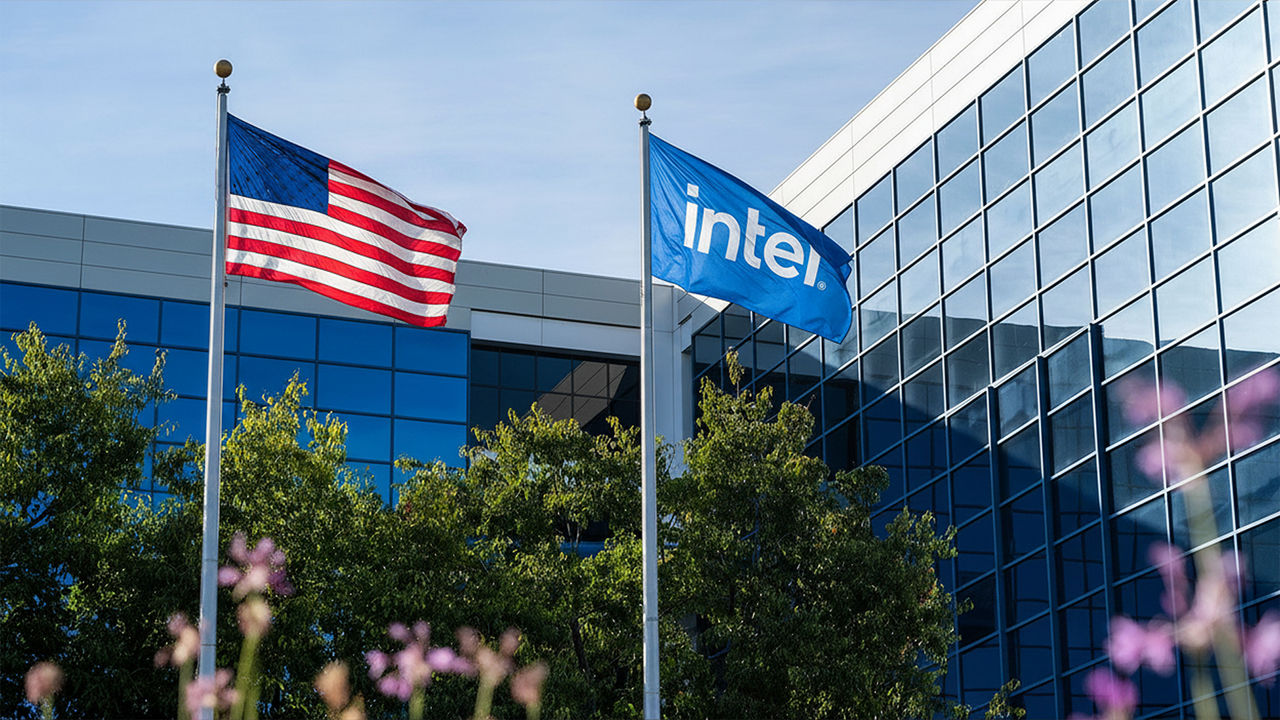 American and Intel flags fly in front of a glass office building.