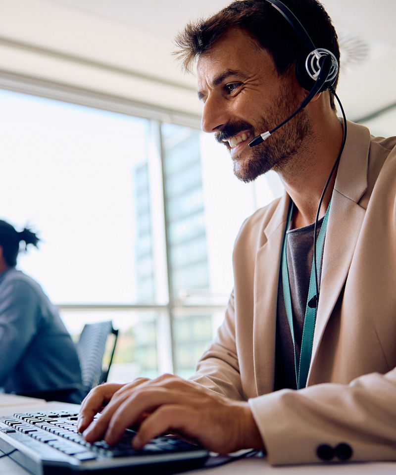 Smiling office worker on a laptop meeting remotely.