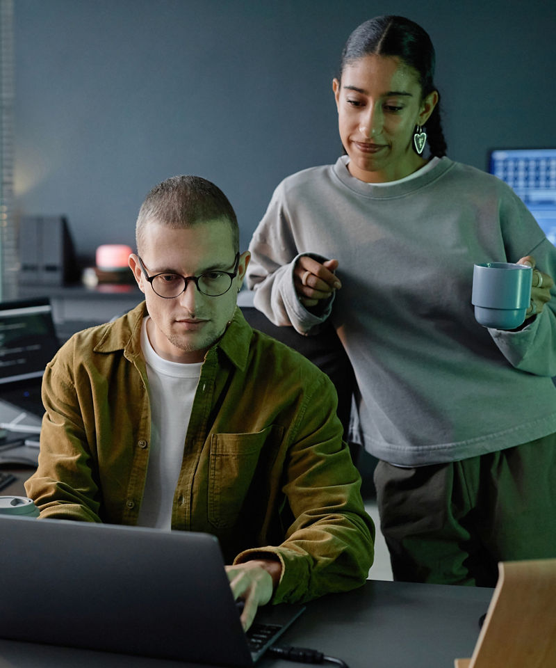 Two coworkers collaborating at a laptop.