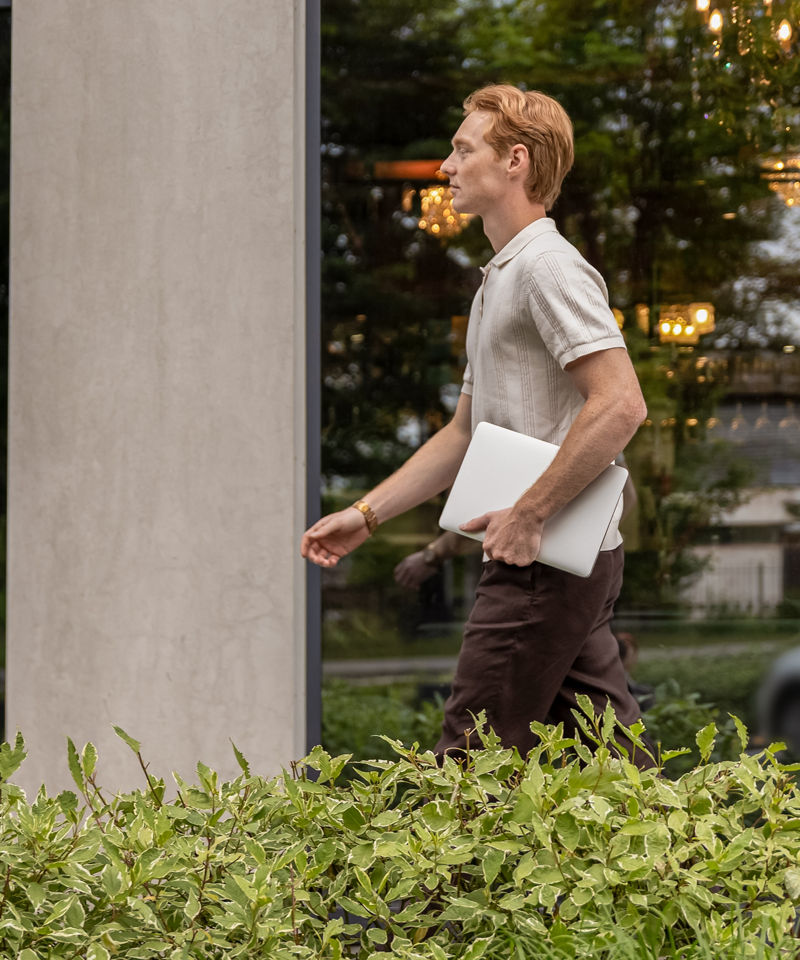 Worker on the move with a laptop, outside an office building.