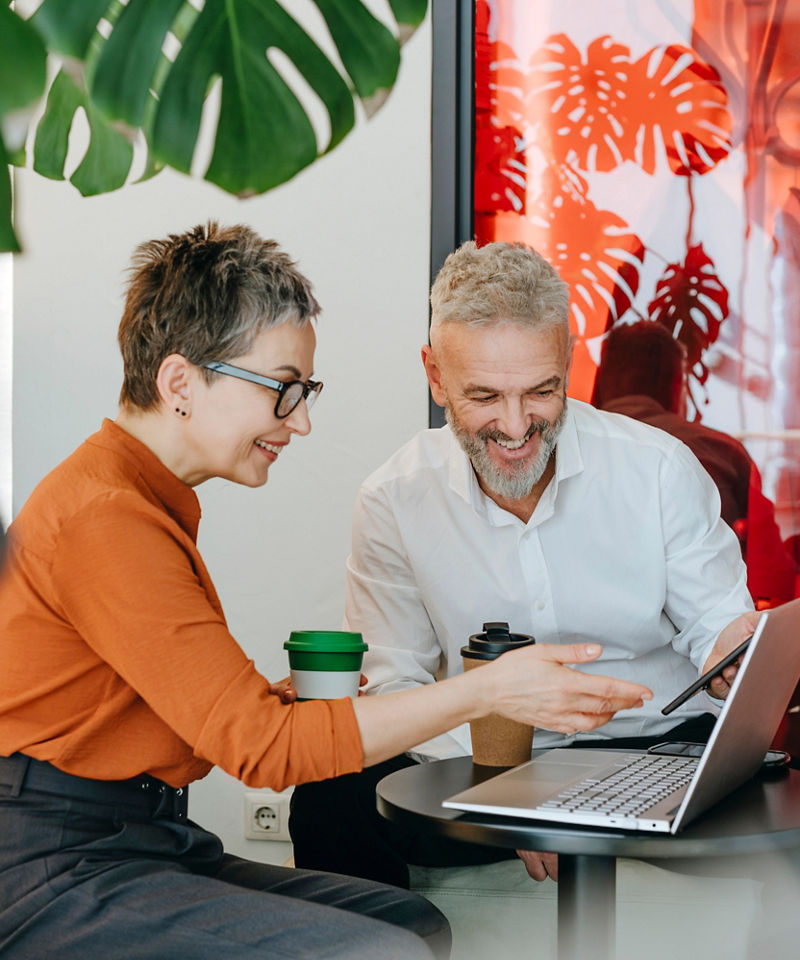 Two coworkers collaborating at a laptop.