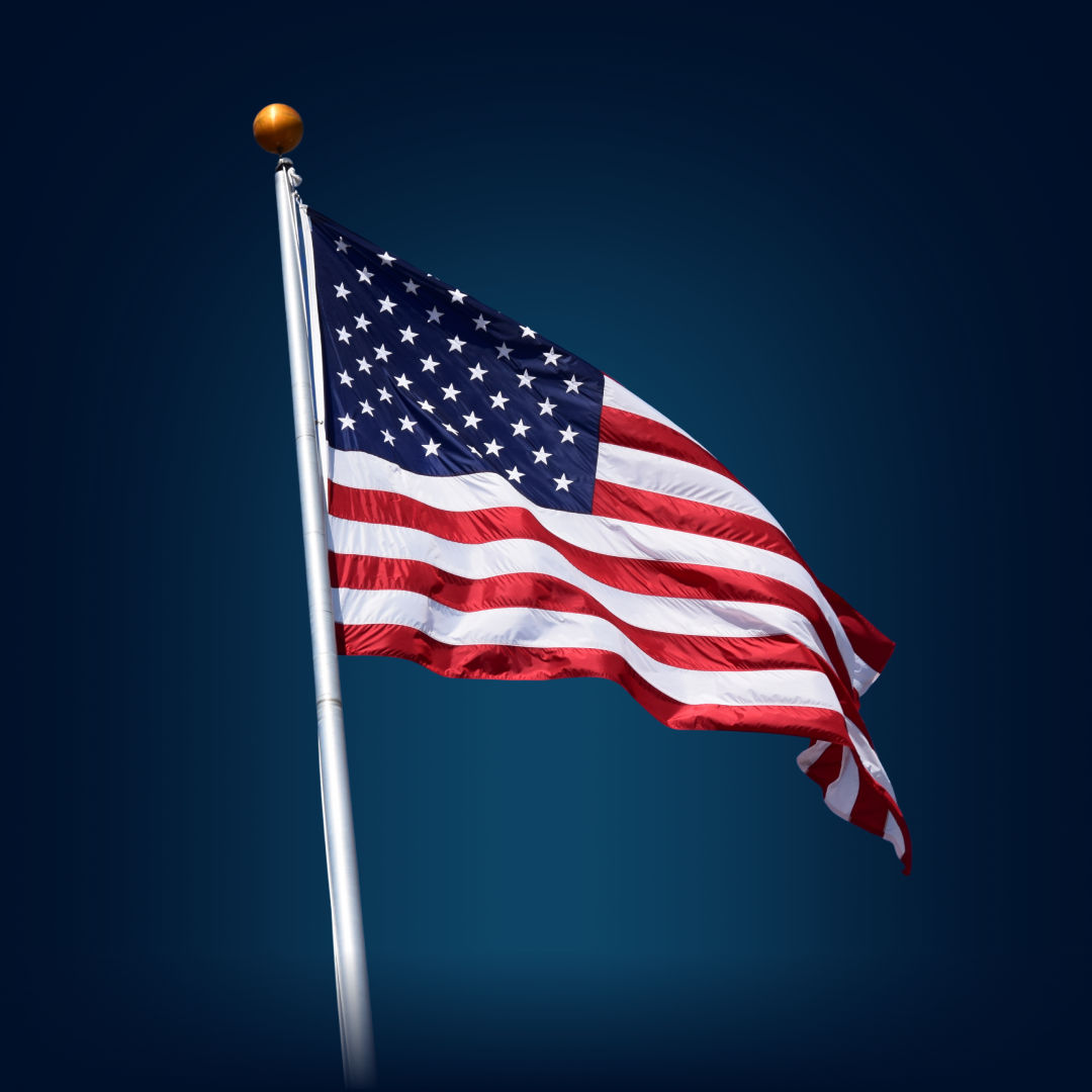 American flag on a flagpole against a clear sky.