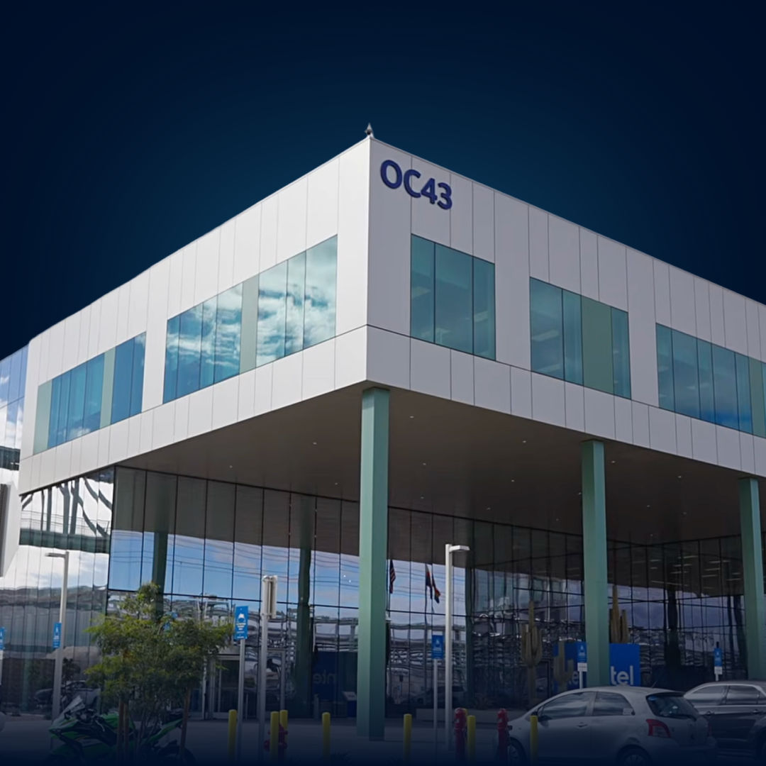 Modern office building with glass windows and covered entryway.