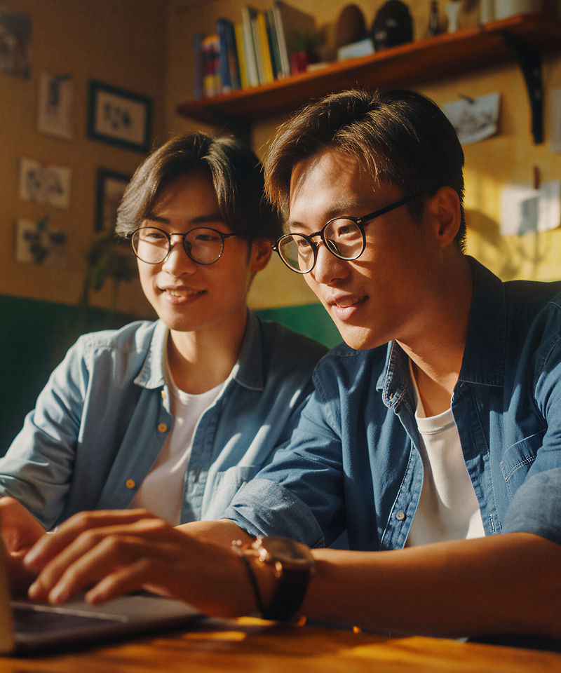 Duas pessoas colaborando enquanto trabalham em um notebook.