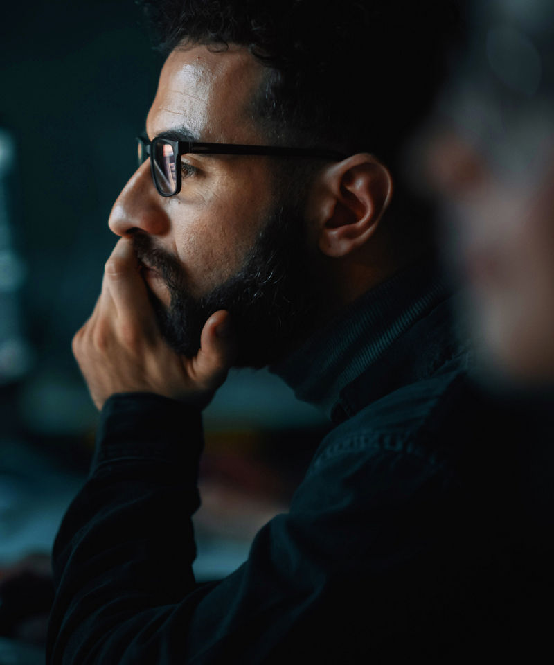 Worker gazing intently at a device screen.